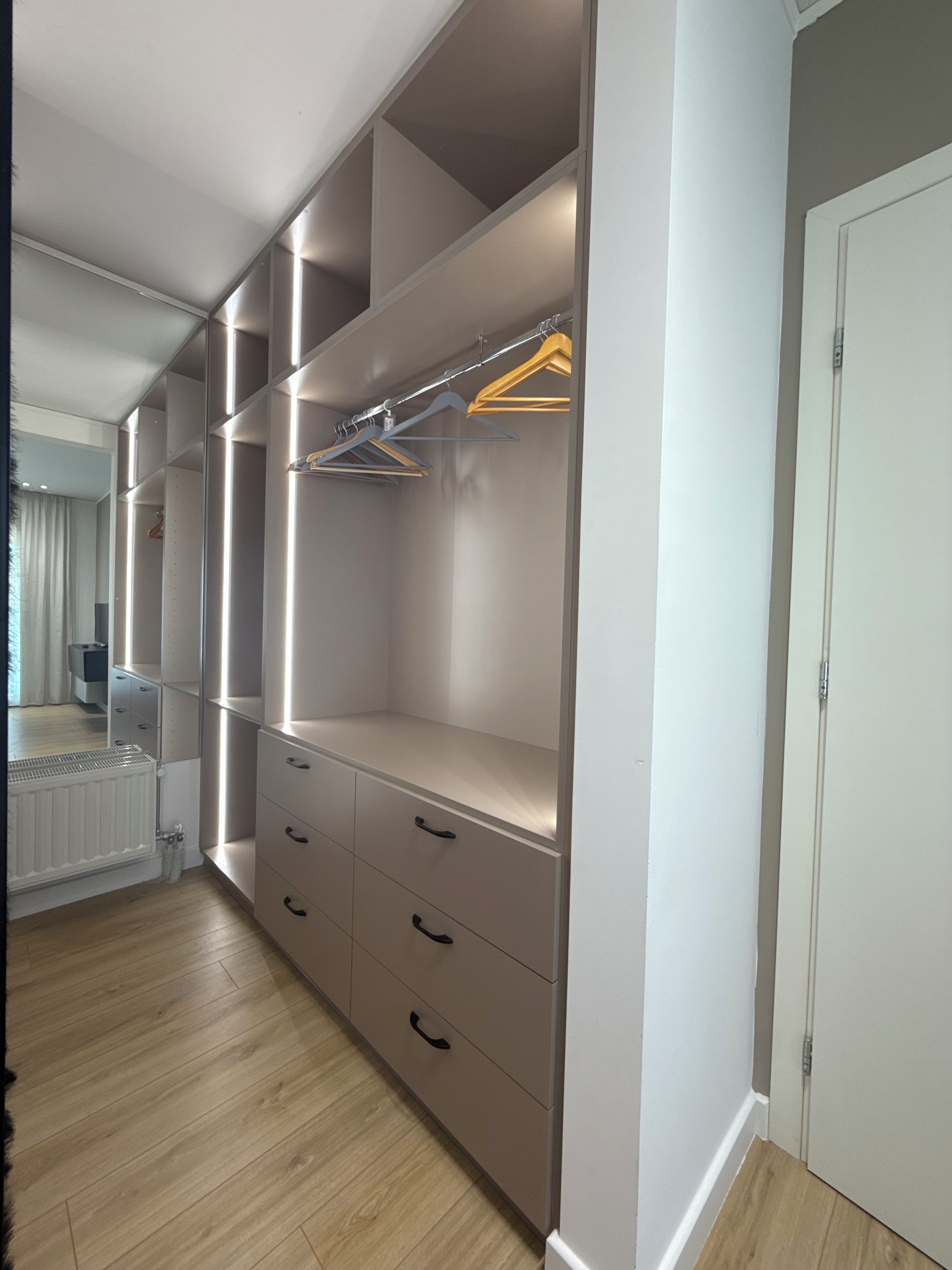 A walk-in closet with open shelving, drawers, and hanging space.