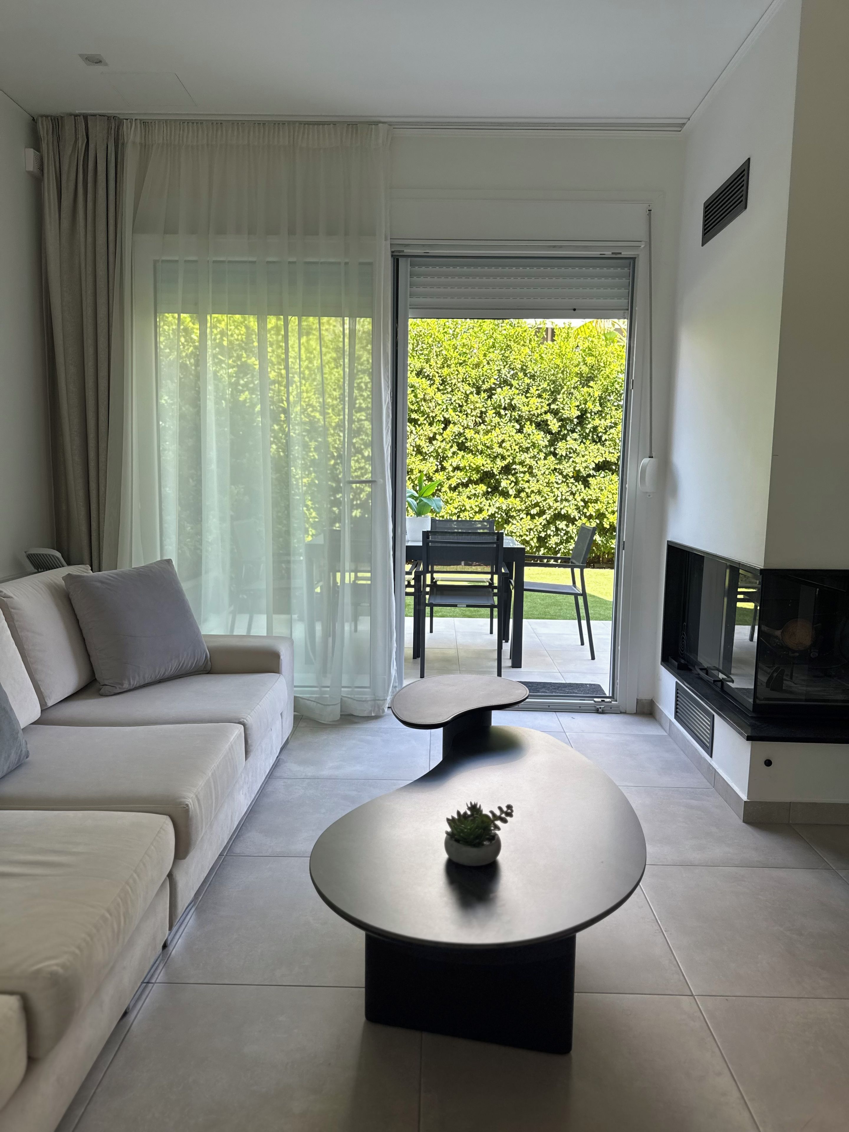 Ein modernes Wohnzimmer mit einer Couch, einem Couchtisch und einem Fernseher.