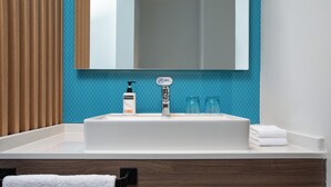 A bathroom with a white sink, a mirror above it, and a blue tiled wall. - Holiday Inn Express Guiyang Qingyan an IHG Hotel (Guiyang)