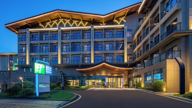 A modern hotel with a prominent entrance, multiple floors, and a well-lit facade. - Holiday Inn Express Guiyang Qingyan an IHG Hotel (Guiyang)