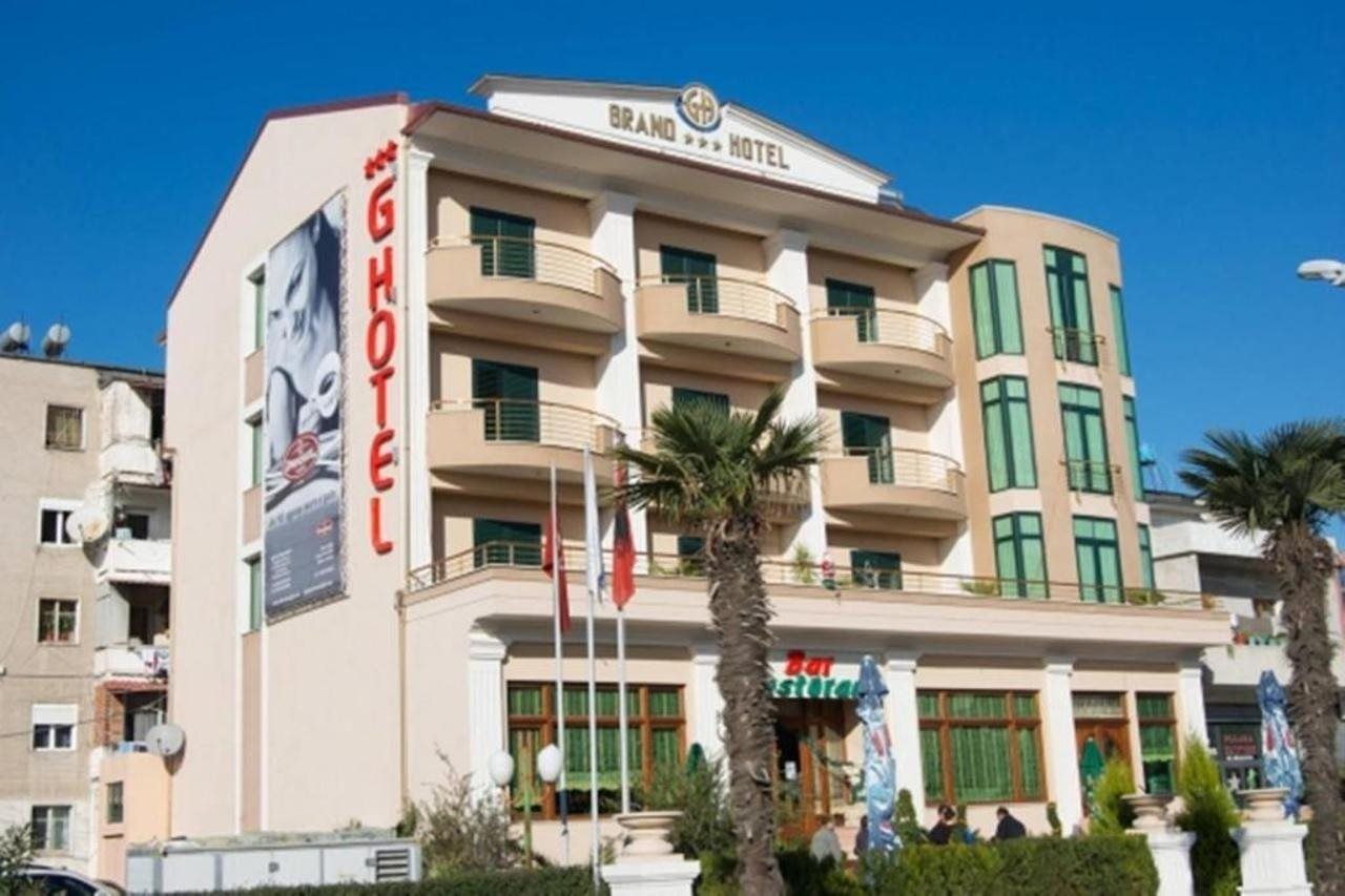 A hotel with a prominent sign, multiple balconies, and a clear sky.