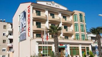 A hotel with a prominent sign, multiple balconies, and a clear sky.