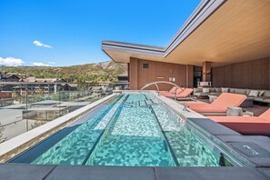 Ein Pool auf dem Dach mit freiem Blick auf die umliegende Landschaft, darunter Berge und andere Gebäude.