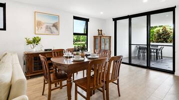 A dining area with a wooden table and chairs, a cabinet, and a painting on the wall.