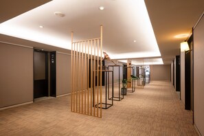 A modern hotel corridor with a wooden partition, a reception desk, and a plant. - Homeinn Select (Shenzhen)