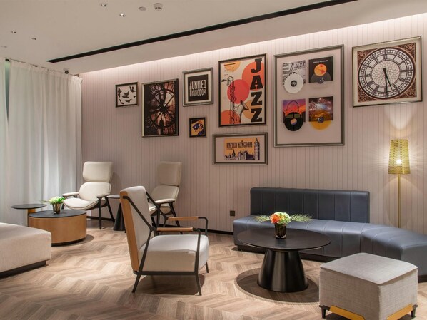 A modern lounge area with a sofa, chairs, and a coffee table. - Homeinn Select (Shenzhen)