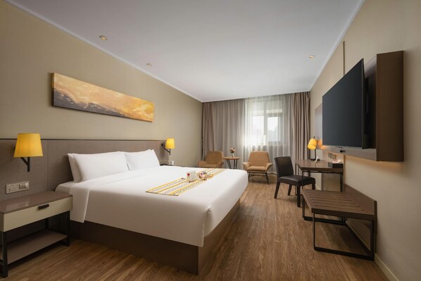 A hotel room with a large bed, bedside tables, a desk, a chair, a TV, and a painting on the wall. - Homeinn Select (Shenzhen)