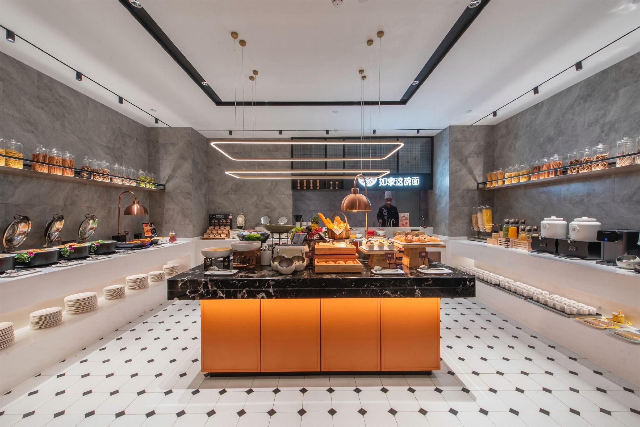 A modern breakfast buffet with a central island, shelves with food items, and a clean, contemporary design.