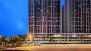 Un edificio moderno de hotel con varios pisos y un letrero llamativo en la parte superior.