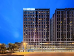 Un edifici d'hotel modern, amb diverses plantes i un rètol destacat al capdamunt.
