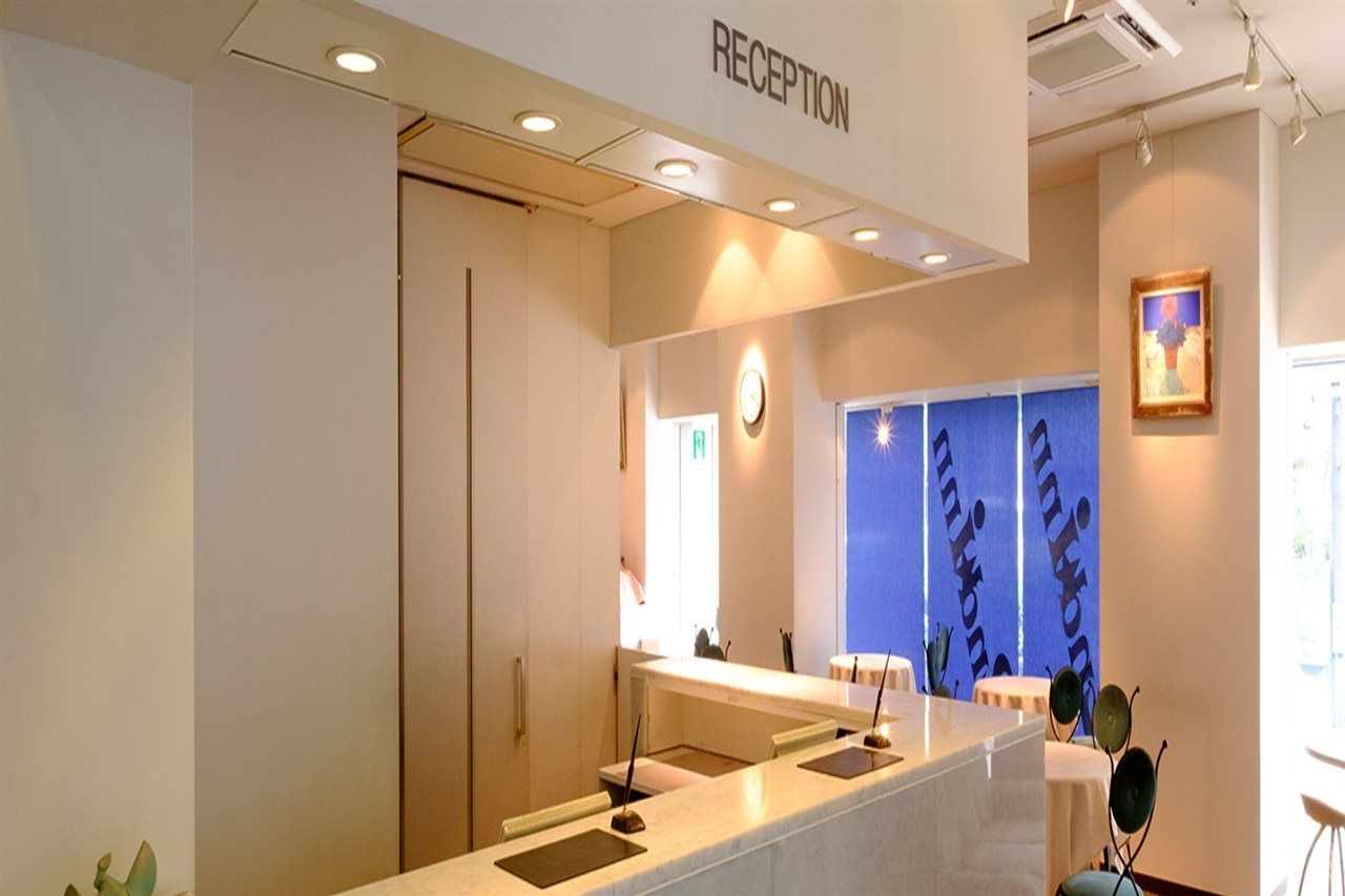 A reception area with a reception desk, a clock, and a wall with vertical text.