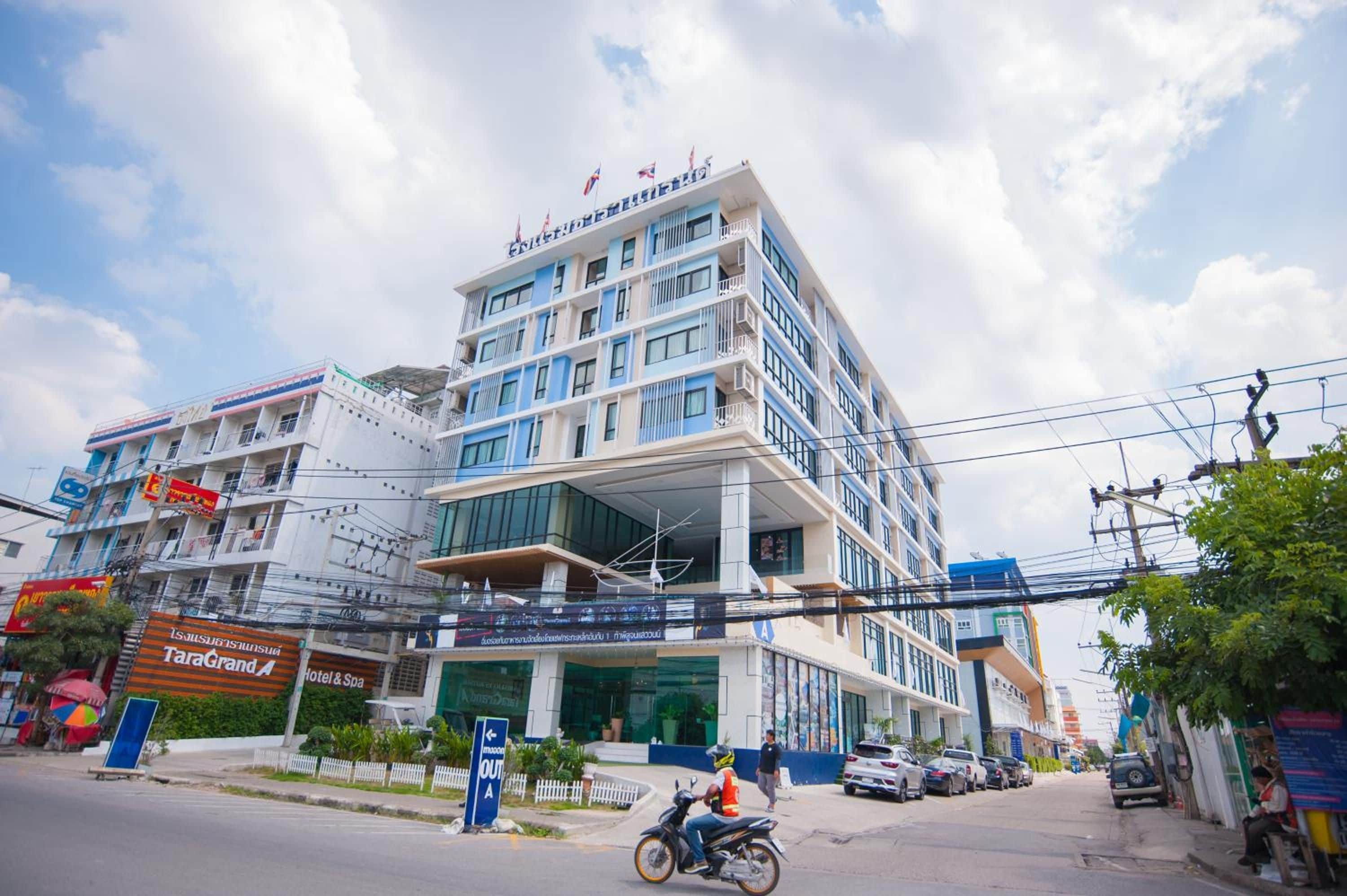 A multi-story hotel with a modern design, featuring balconies and large windows.