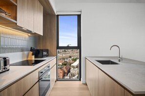 Eine moderne Küche mit Blick auf eine Stadt durch ein großes Fenster.