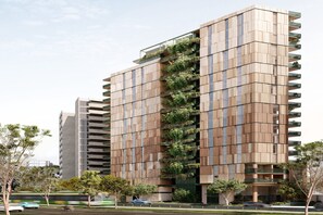 Un edificio moderno de gran altura con varios balcones y un jardín vertical.