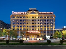 Un grand hôtel à plusieurs étages, doté d’une façade symétrique, de nombreuses fenêtres et d’une entrée centrale.