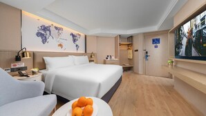 A hotel room with a large bed, a desk, a chair, a world map on the wall, and a television. - Kyriad Marvelous Hotel Shenzhen Nanlian Metro Station (Shenzhen)