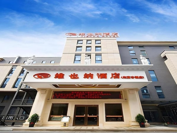 A hotel with a prominent sign and a modern facade. - Vienna Hotel (Suzhou)