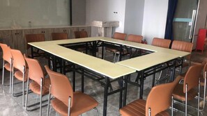 A conference room with a large rectangular table surrounded by chairs, a whiteboard, and a red cabinet. - 7 Days Premium Hotel (Chongqing)