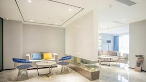 A modern hotel room with a sofa, two chairs, a coffee table, and a glass partition. - 7 Days Premium Hotel (Chongqing)