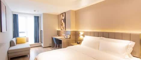 Una habitación de hotel con una cama grande, un escritorio, una silla y un sofá.