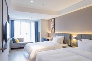 A hotel room with two beds, a sofa, a desk, and a large window with curtains. - 7 Days Premium Hotel (Chongqing)