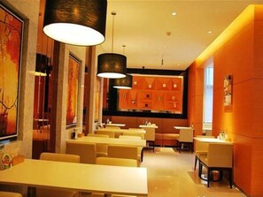 Un ristorante con diversi tavoli e sedie, illuminazione a sospensione e un arredamento dal design moderno.