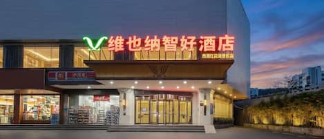 A hotel with a modern facade, large glass windows, and a prominent signage.