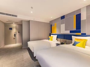 A hotel room with two beds, a headboard with a geometric design, and a door with a digital display. - 7 Days Inn (Beijing)