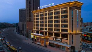 A hotel with multiple floors, a prominent sign for 'Cangli Hotel,' and a large entrance with a visible storefront. - Campanile (Shenzhen)