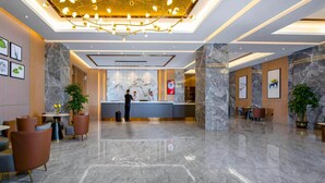 A modern hotel lobby with a marble floor, a reception desk, and a chandelier. - Campanile (Shenzhen)