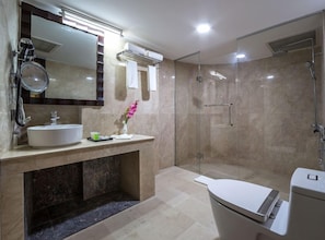 Un baño moderno con ducha acristalada, lavamanos con espejo e inodoro.