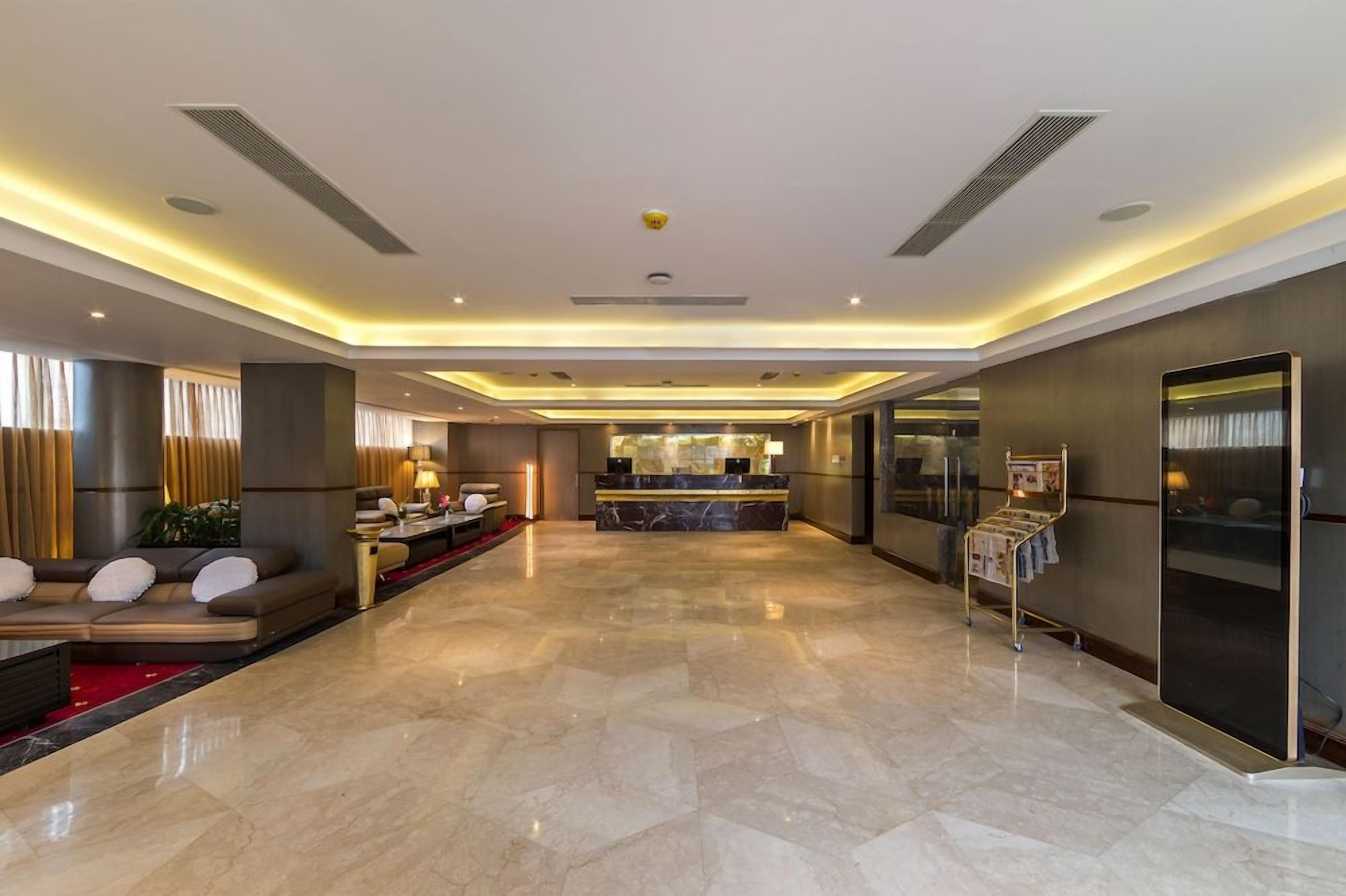 A spacious lobby with a reception desk, seating area, and a modern design.