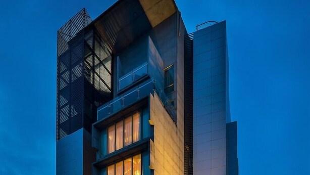 A multi-story building with a modern architectural design, featuring a prominent entrance with glass doors and a visible restaurant sign. - Grand Palace Rangpur (Rangpur)