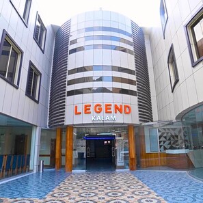 Un edificio moderno con fachada curva y el nombre 'LEGEND KALAM' visible en grande.