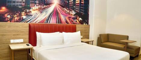 A hotel room with a large bed, a red headboard, a brown sofa, and a cityscape mural on the wall.