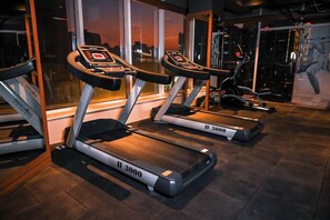 Ett gym med löpband märkta med ”JF 3000” och en motionscykel.
