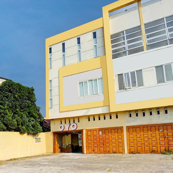 Un edificio de varios pisos con fachada amarilla y un letrero que dice 'OYO'.