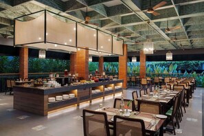 Un restaurante con un amplio comedor, una barra central y un techo con vigas a la vista.