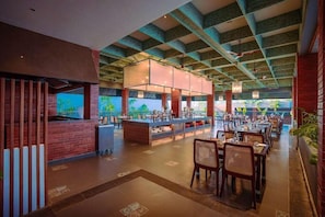 Un restaurante espacioso con techos altos, vigas a la vista y una isla central.