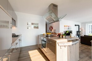 A modern kitchen with a central island, built-in oven, and stainless steel appliances. - Holiday apartment with 2 bedrooms (Kappeln)