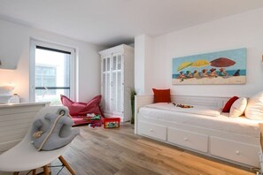 A child's play area with a white sofa, a red bean bag chair, and a painting of a beach scene. - Holiday apartment with 2 bedrooms (Kappeln)