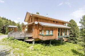 Eine Holzhütte mit geneigtem Dach, einem Balkon und einer Satellitenschüssel.