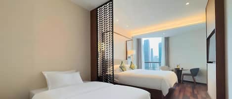 Habitación de hotel con dos camas, un escritorio y vistas a la ciudad.