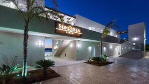 A resort with a prominent sign, a covered walkway, and a staircase leading to the entrance. - Sun & Sea Plus Resort (Apokoronas)