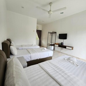 A hotel room with two beds, a ceiling fan, a TV, and a mirror.