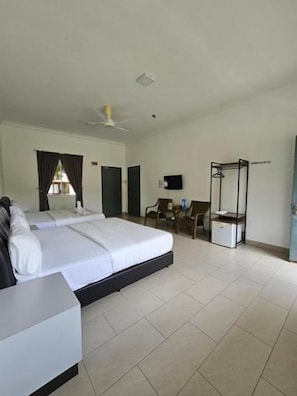 A hotel room with a bed, a desk, a chair, a TV, and a wardrobe.