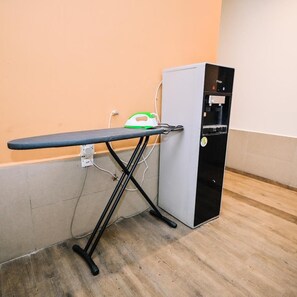 A room with a wooden floor, a wall-mounted ironing board, and a water dispenser. - Swing & Pillows Myhome Wangsa Maju (Kuala Lumpur)