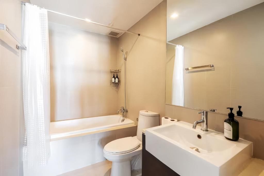 Une salle de bain moderne avec une baignoire, des toilettes et un grand lavabo.