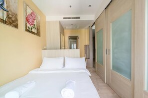 Una habitación de hotel con una cama grande, un espejo y obras de arte en la pared.