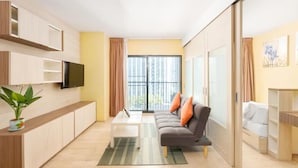 A modern living room with a sofa, coffee table, and a flat-screen TV mounted on the wall. - Noble Remix Bangkok (Krung Thep Maha Nakhon)